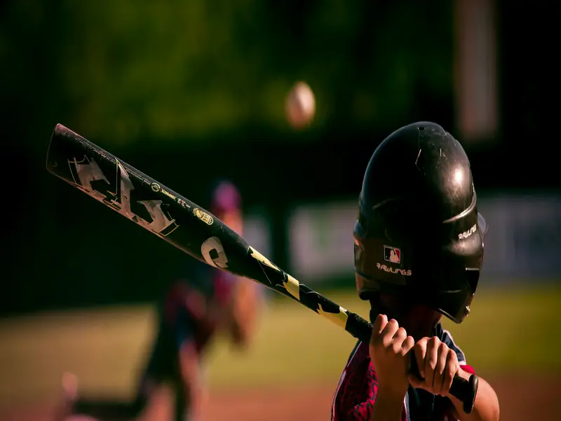 A hitter in a helmet loading up, bat across the frame.